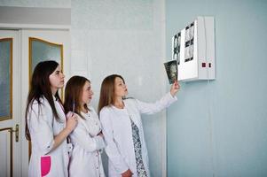 Skillful doctors are looking at x-ray image of their patient's body part in the hospital. photo