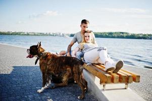 Couple in love with two dogs pit bull terrier against beach side. photo