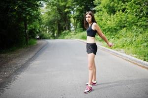 chica deportiva en ropa deportiva haciendo ejercicio en un parque verde y entrenando en la naturaleza. un estilo de vida saludable. foto