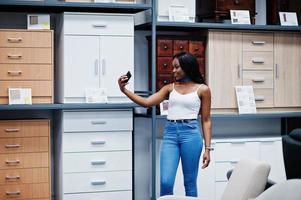 Portrait of a beautiful african american woman taking a selfie in the shop. photo