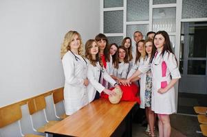 Young female doctors doing cardiopulmonary resuscitation on a training robot. photo