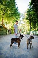 hombre con dos perros pit bull terrier en un paseo. foto