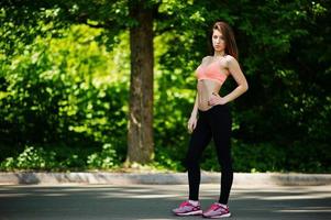 Fitness sport girl in sportswear posed at road in park, outdoor sports, urban style. photo