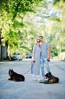 Couple in love with two dogs pit bull terrier on a walk. photo