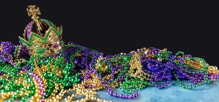 New Orleans mardi gras crown and beads in green, gold, and purple with copy space photo