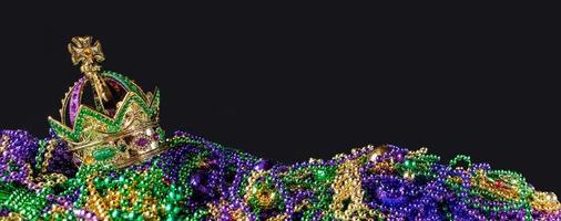 New Orleans mardi gras crown and beads in green, gold, and purple with copy space photo
