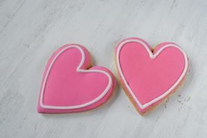 Pink Heart-shaped cookies with icing detail on white background photo