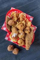 seafood basket with fried shrimp, fish, and hush puppies flat lay photo