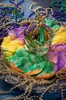 pastel de rey con corona rodeado de cuentas de mardi gras foto