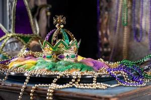 king cake with crown surrounded by mardi gras beads side view photo