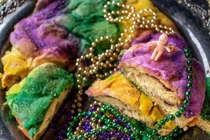 king cake with baby surrounded by mardi gras beads photo