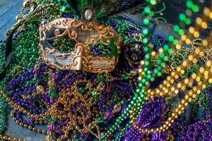 mardi gras mask and beads in green, gold, and purple photo