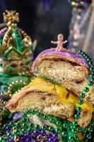 king cake with baby surrounded by mardi gras beads photo