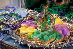 pastel de rey con corona rodeado de cuentas de mardi gras foto