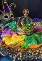 pastel de rey con corona rodeado de cuentas de mardi gras foto