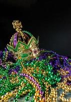 New Orleans mardi gras crown and beads in green, gold, and purple with copy space photo