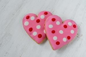 Pink Heart-shaped cookies with icing detail on white background photo