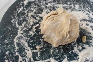 Dough ball on floured marble in kitchen photo
