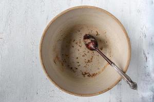 empty country crock bowl with wooden spoon and leftover crumbs flat lay photo