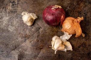 isolated onions and garlic on dark metal background flat lay photo