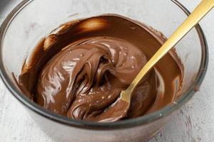 glass bowl of melted chocolate with spoon photo