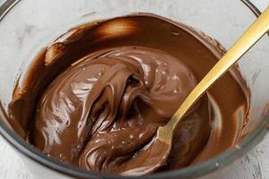 glass bowl of melted chocolate with spoon photo