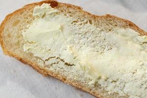 Primer plano de rebanadas de pan de campo untado con mantequilla foto