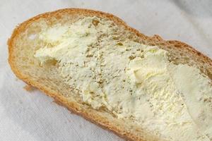 Primer plano de rebanadas de pan de campo untado con mantequilla foto