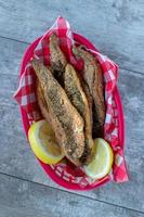 red and white checkerboard seafood basket of fried mullet fish and lemons flat lay photo