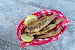 red and white checkerboard seafood basket of fried mullet fish and lemons flat lay photo