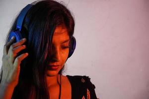 a asian girl having headphone and listening music photo