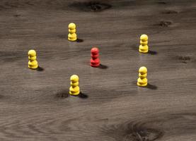 Yellow wooden pegs surrounding red one to illustrate leadership or social media communication photo