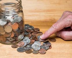 Loose USA change with mixed coins on wooden table with savings jar photo