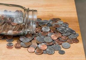 Loose USA change with mixed coins on wooden table with savings jar photo