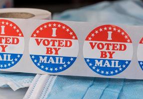 voté por correo con una pegatina de papel en una mascarilla médica para ilustrar la votación por correo en las elecciones foto