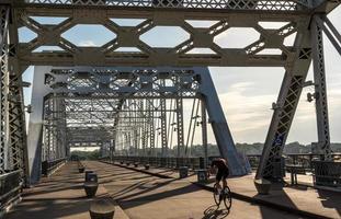 ciclista en el puente peatonal john seigenthaler o en el cruce de la calle shelby al amanecer en nashville foto