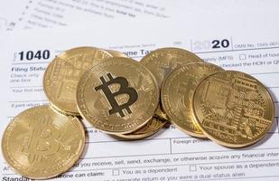 Form 1040 with bitcoin coins for reporting cyber currency gains photo