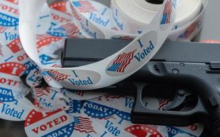 Many torn voting campaign buttons with handgun as concept for for voter suppression photo