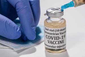 Close up of the end of the hypodermic syringe with droplet of vaccine photo