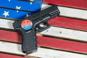 Concept of protecting against voter fraud with firearm and voting sticker photo