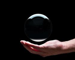 Hand holding a crystal glass forecasting ball with black center to allow easy composites photo