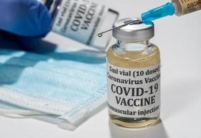 Close up of the end of the hypodermic syringe with droplet of vaccine photo