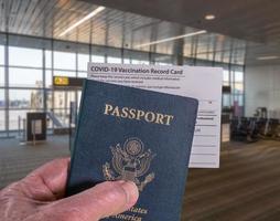 Concept of Covid-19 vaccination record certificate and US passport to show immunity to virus at airport photo