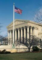 Supreme Court in Washington DC with the US flag flying in front of the building photo