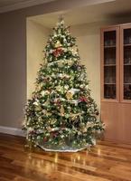 Ornately decorated christmas tree in the corner of a modern family room photo