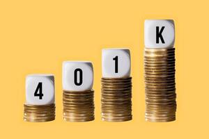 Stacks of gold coins with cubes spelling 401K to show rise in value photo