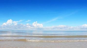 vagues de la mer le matin avec ciel bleu et fond de nuages blancs. plage de sable blanc de la mer naturelle avec un ciel bleu. video