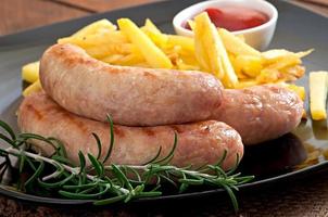 Chicken sausages grilled with a side dish of  french fries photo