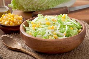 Chinese cabbage salad with sweet corn in a wooden bowl photo