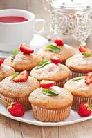 Strawberry muffin on a white plate with a fresh strawberry photo